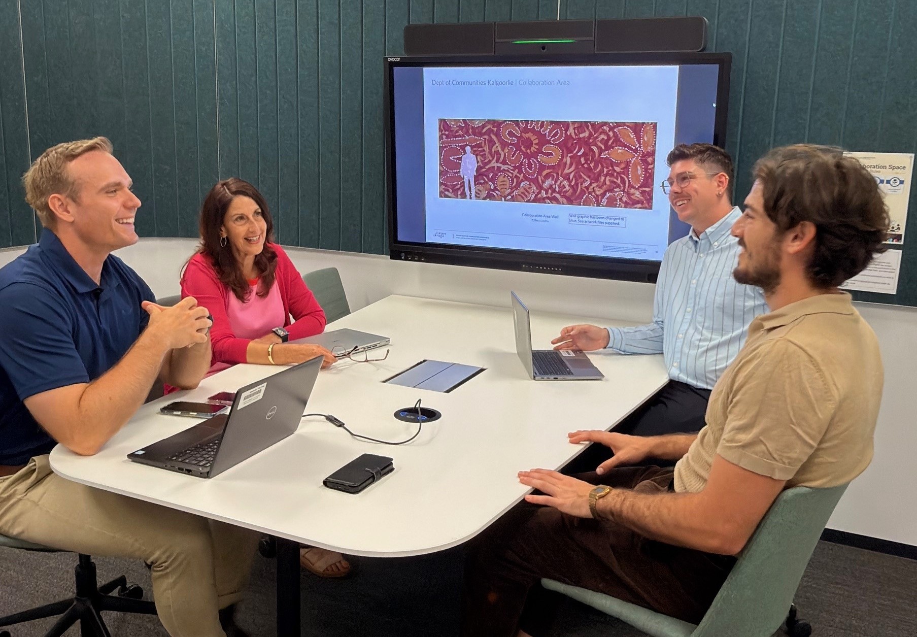 Four Department of Communities staff in a meeting room having a meeting