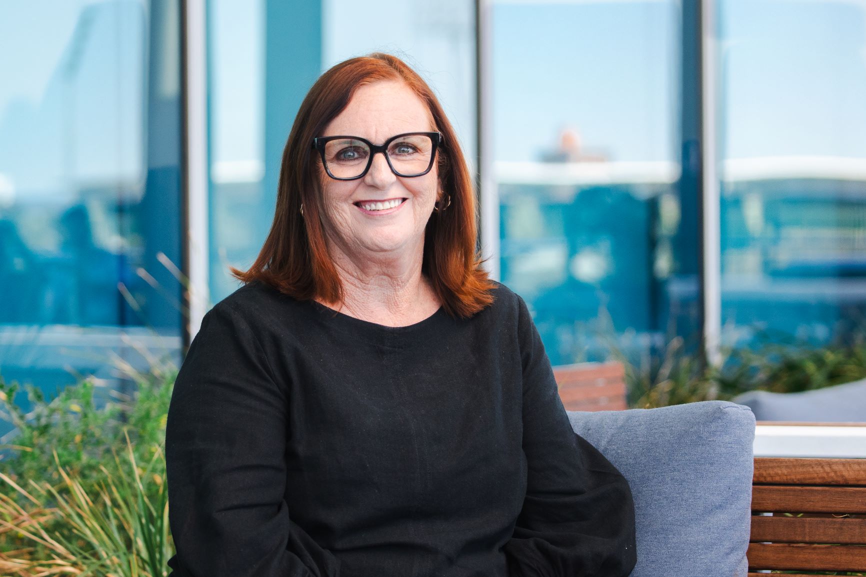 a woman smiling dressed formally in an outdoor setting