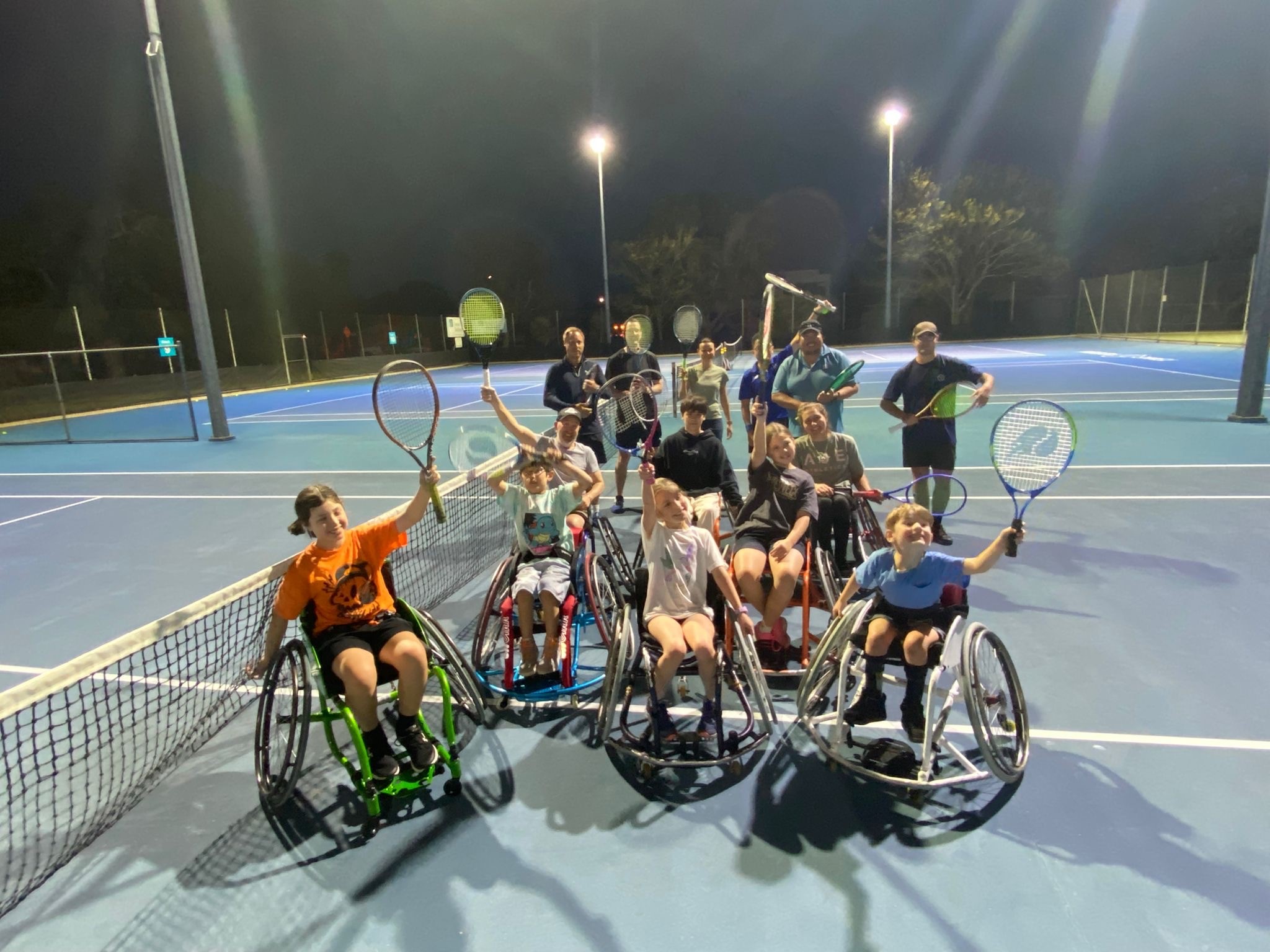 A group of wheel-chair tennis players on a tennis court