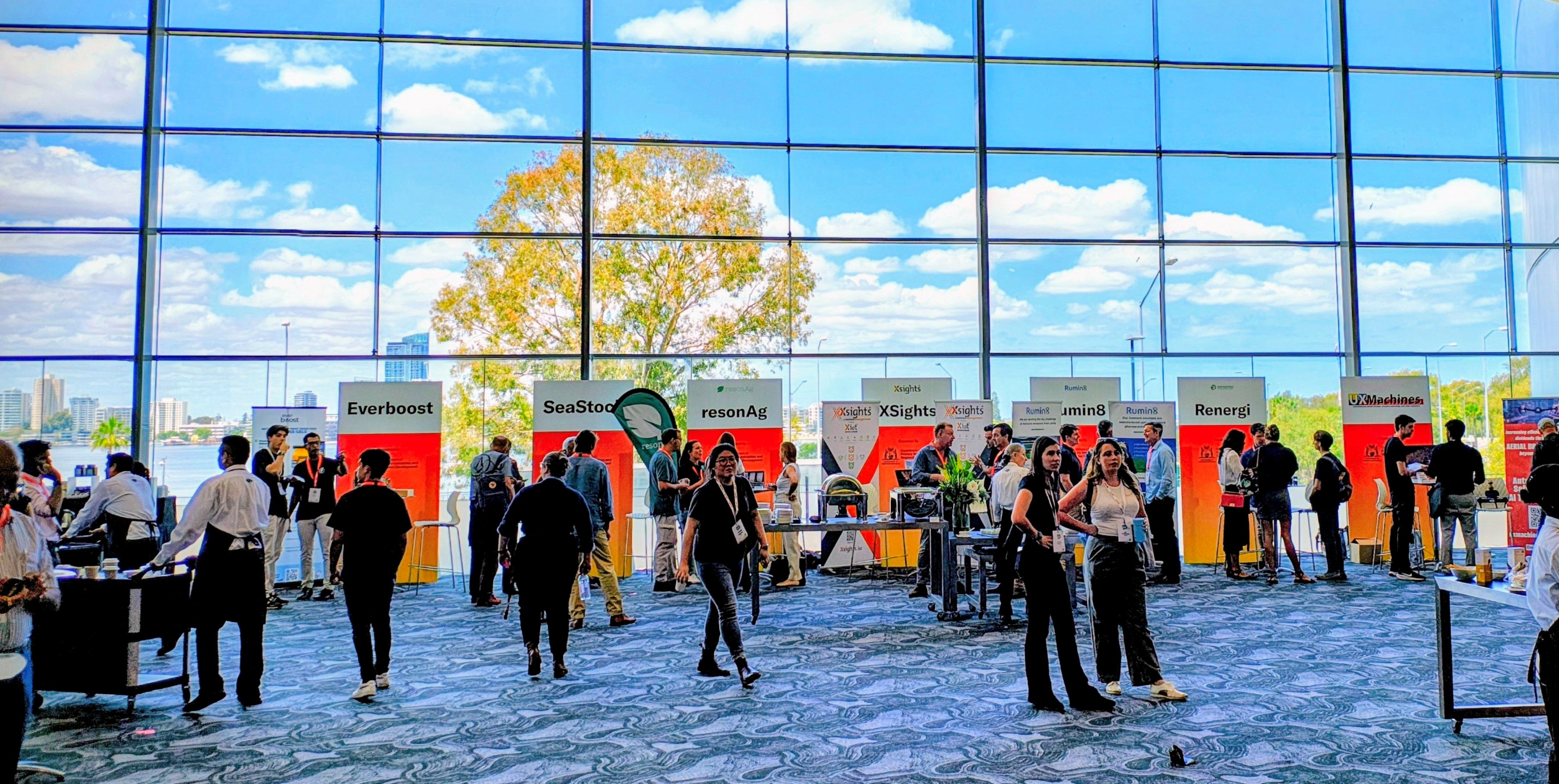 A long shot of people milling around an exhibition centre.