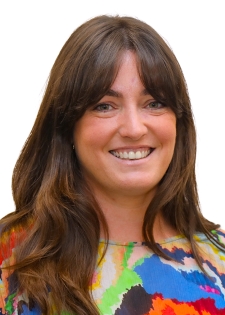 a woman, smiling, she has long hair, head and shoulders image