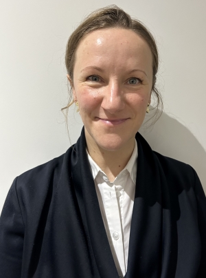 a well-dressed woman, smiling, head and shoulders pictured