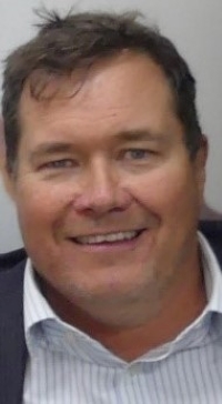 a middle age man, well dressed, smiling.