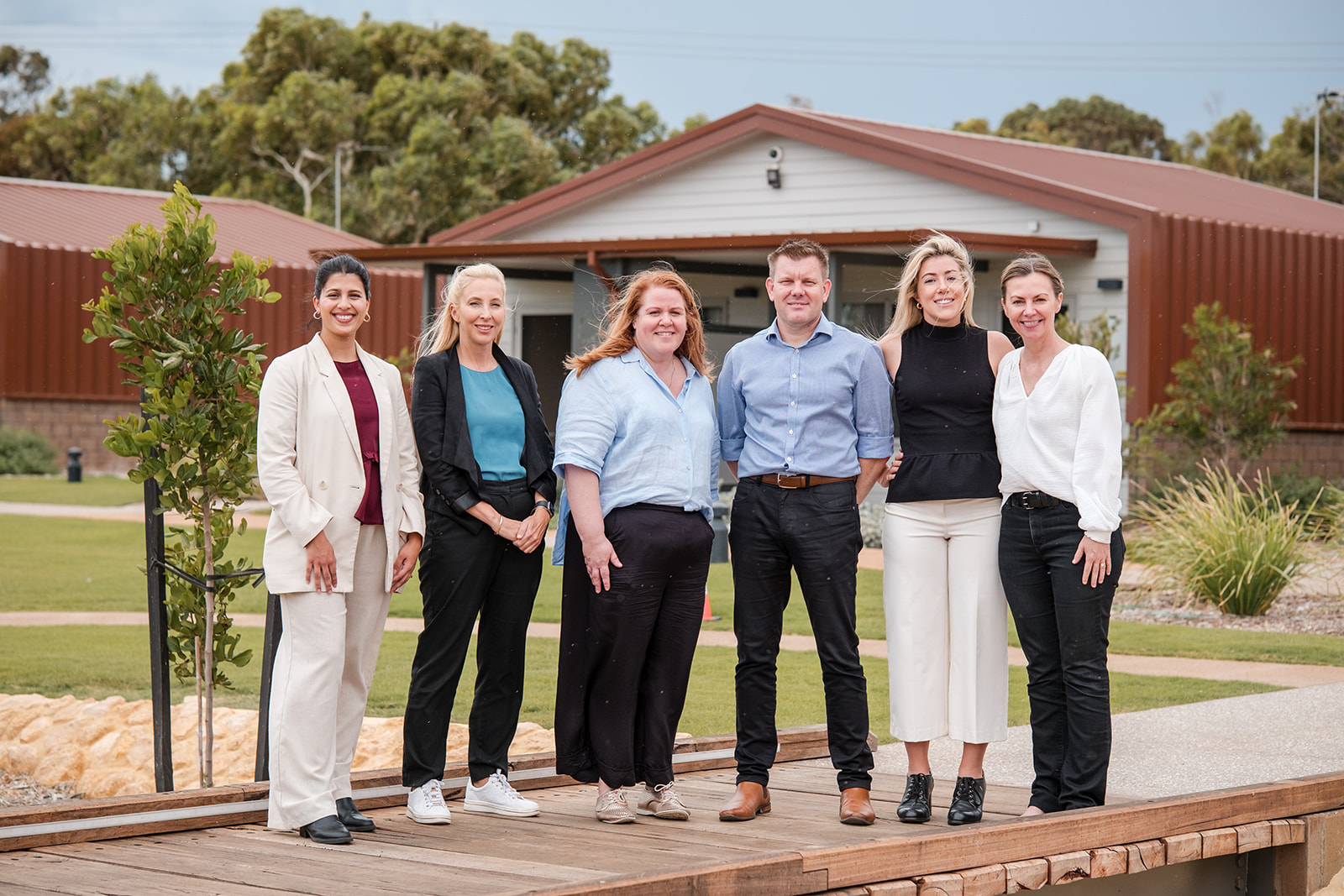 a group of well-dressed adults standing outside the Geraldton Short Stay building