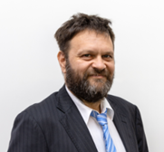 michael is wearing a suit and smiling at the camera