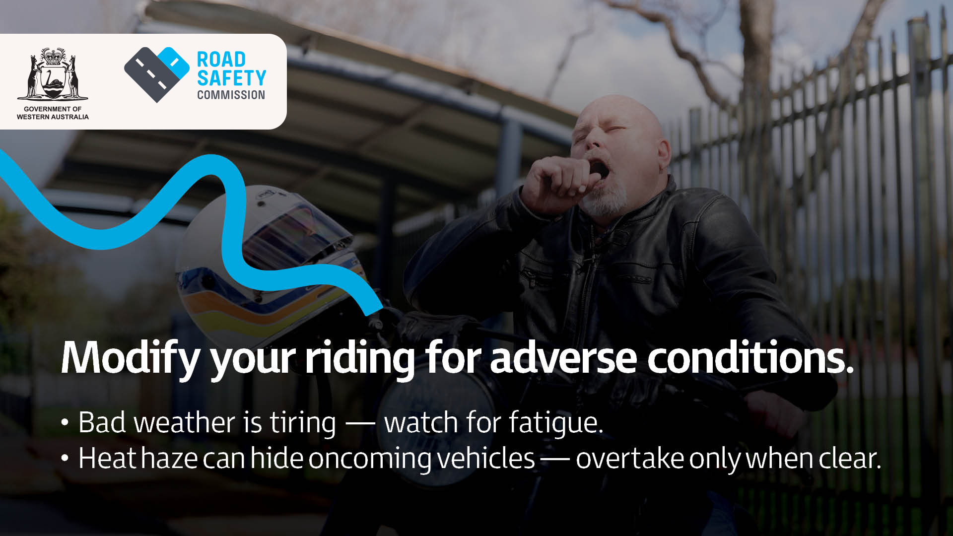 A motorcyclist yawns from exhaustion during a break from riding