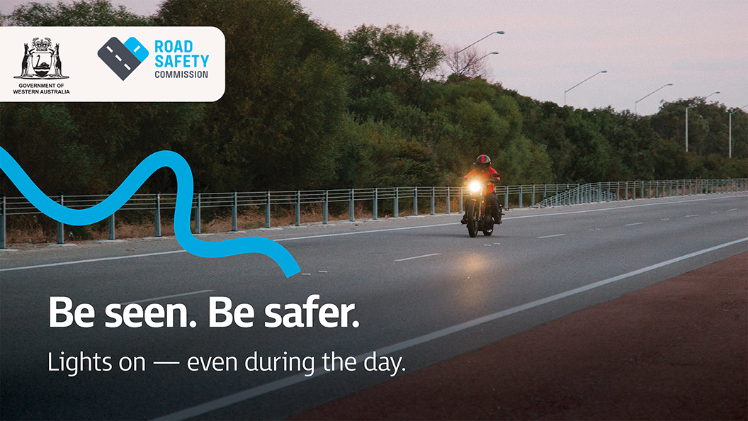 A motorcyclist riding during the day with their light on