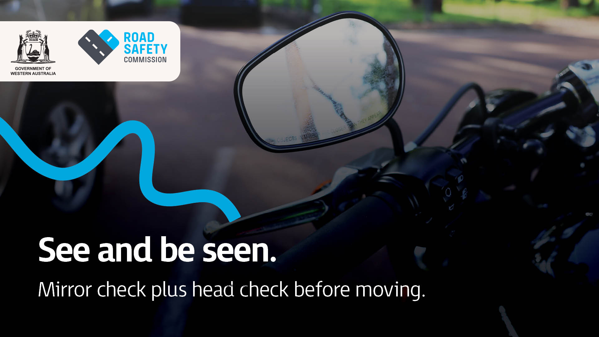 Image of a motorcycle mirror showing with a rider prepared to drive