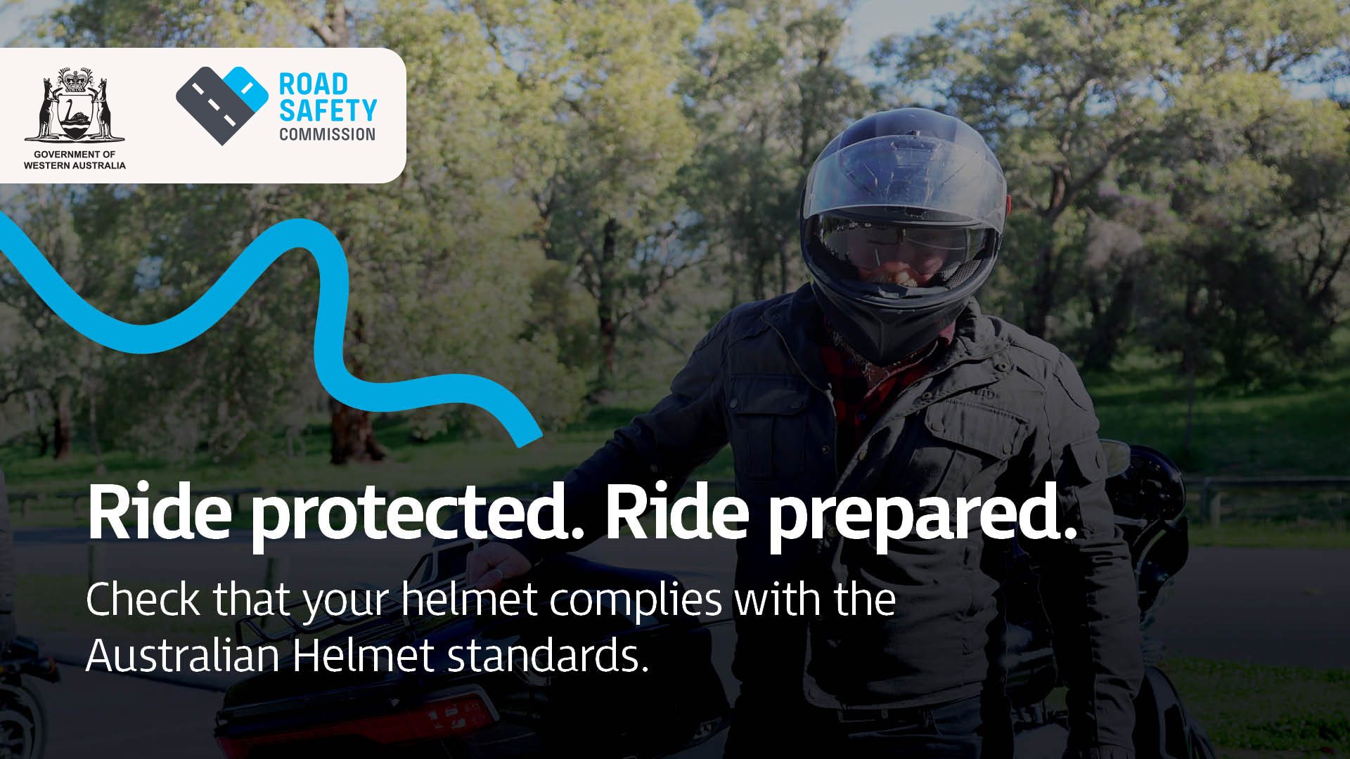 A motorcyclist wearing a helmet standing next to a motorcycle