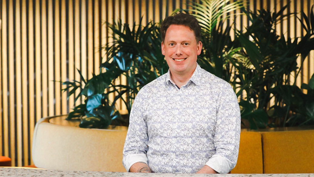 a man smiling, well dressed, in an indoor setting