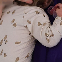 Baby being carried by a carer