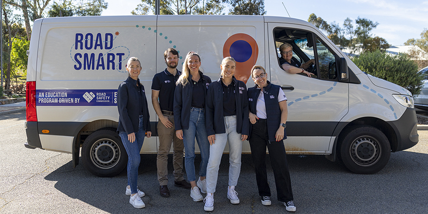 The Road Smart KickStart team from the Road Safety Commission poses in front of the Road Smart van.