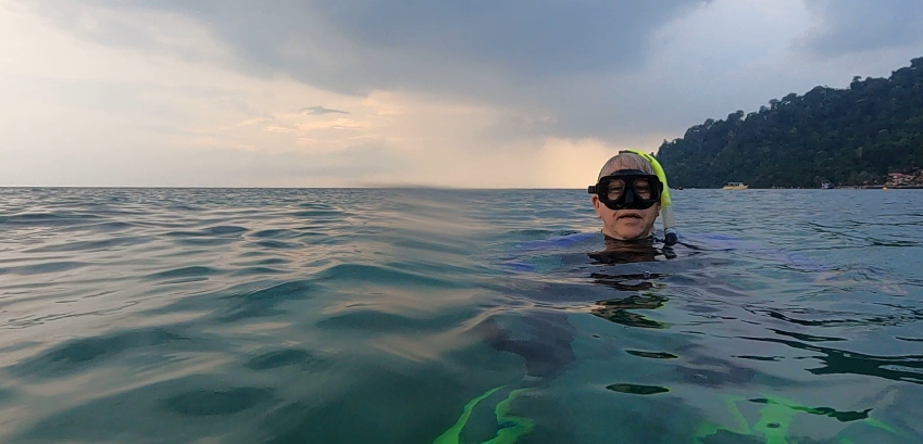 a middle age man snorkeling in the ocean
