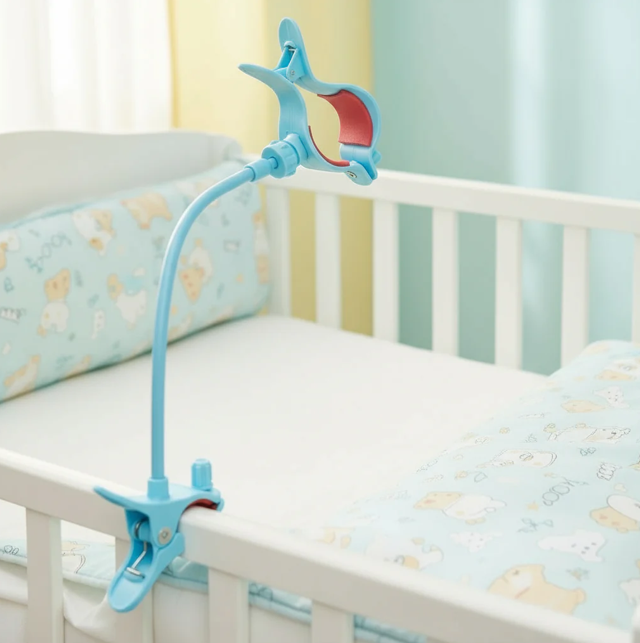 Photo of baby bottle self-feeding device attached to a cot