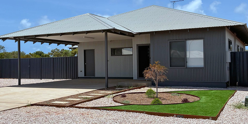 Street view of a new house with a garden.