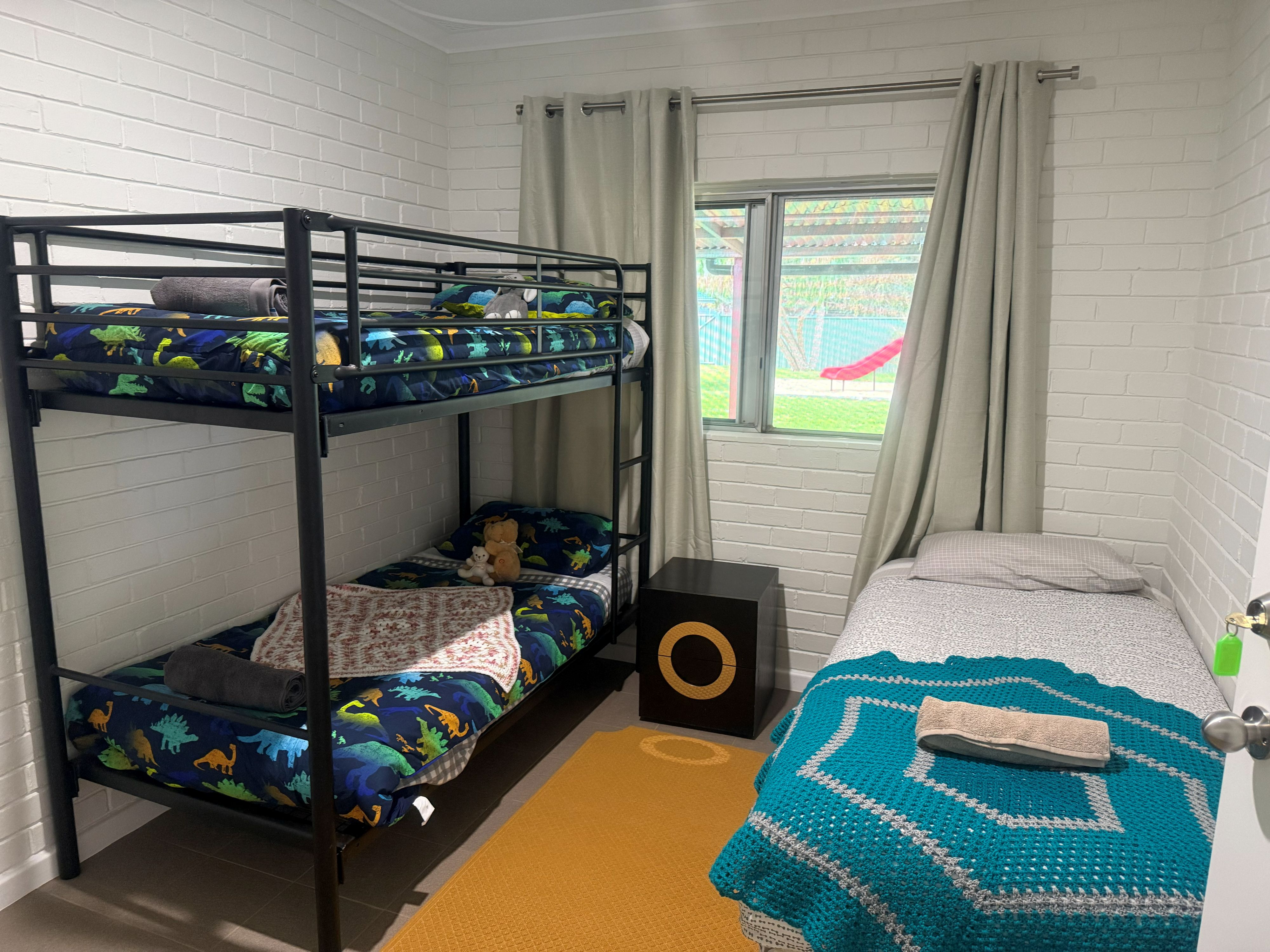 a children's bedroom with a twin bunk bed and a single bed