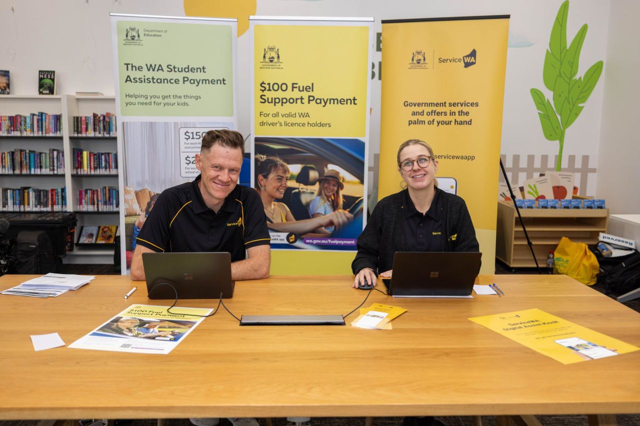 two people sitting at a table and smiling at the camera