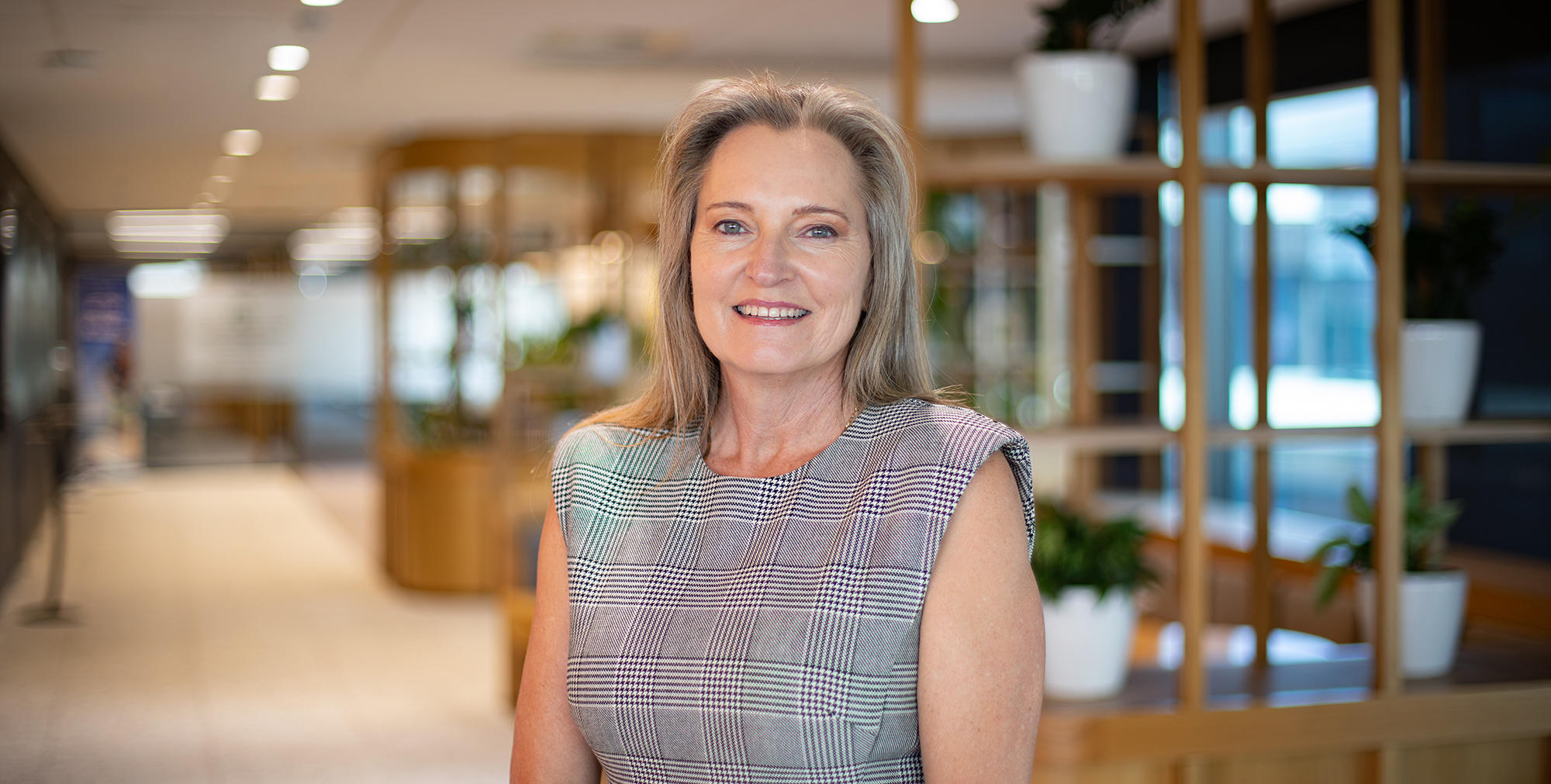 a middle aged woman in a professional workplace setting, smiling