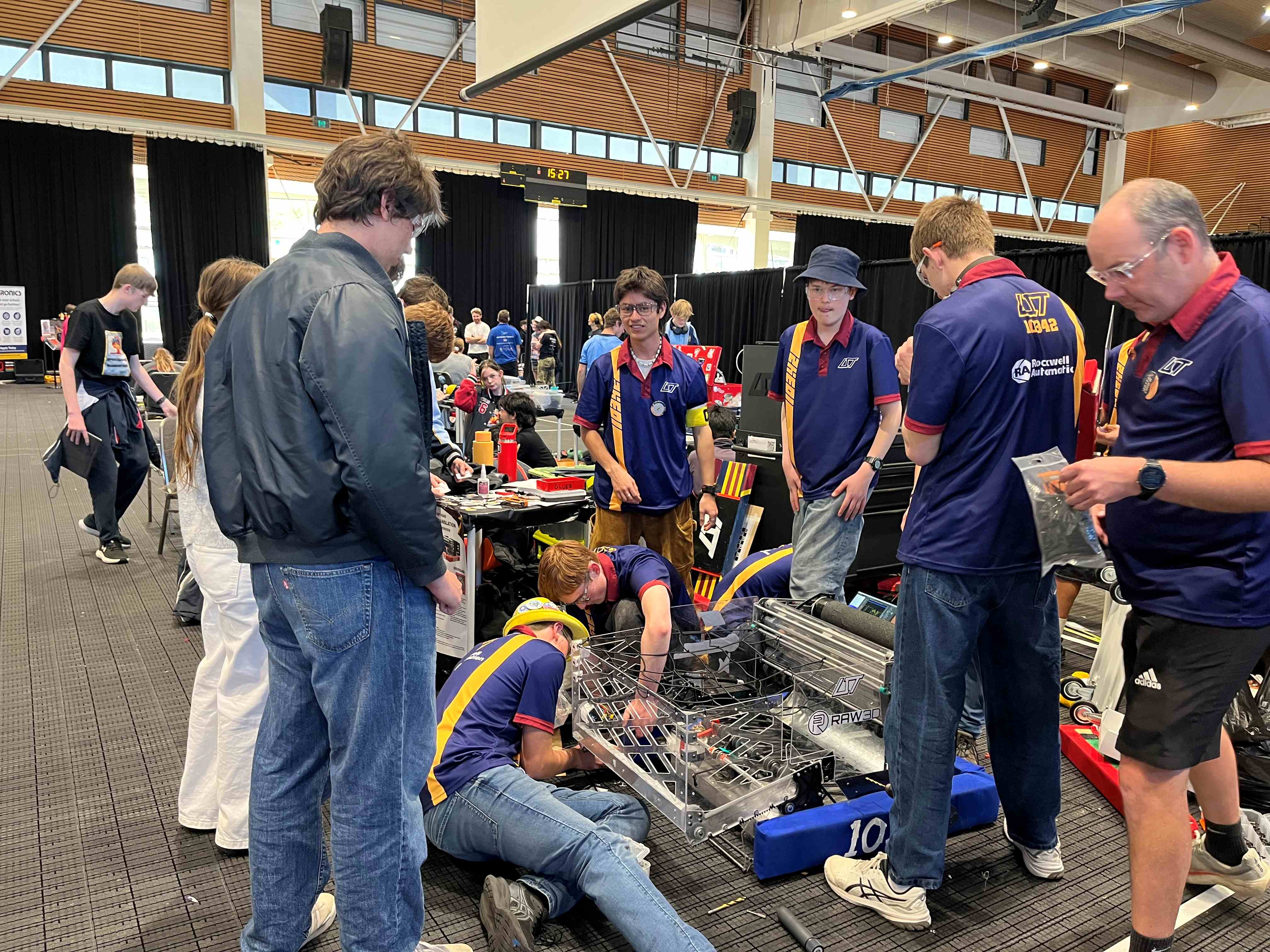 A group of people looking at a person on the floor holding plastic. 