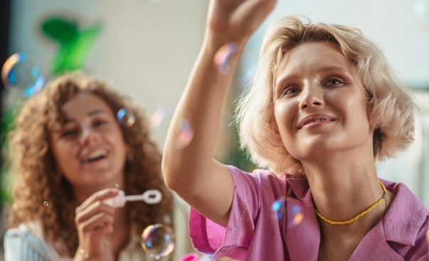 two women blowing bubbles