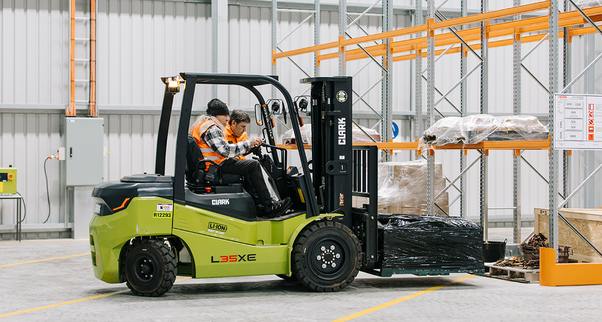 Person operating a forklift during training in a warehouse environment.