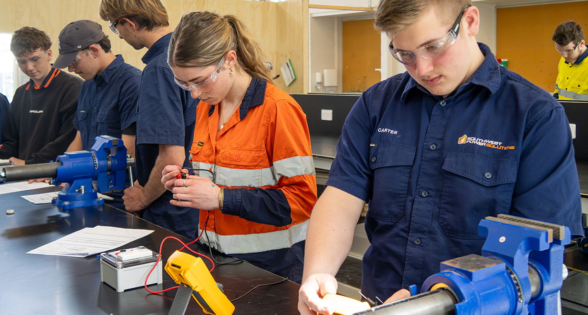 Students completing electrical training activities in a classroom workshop.