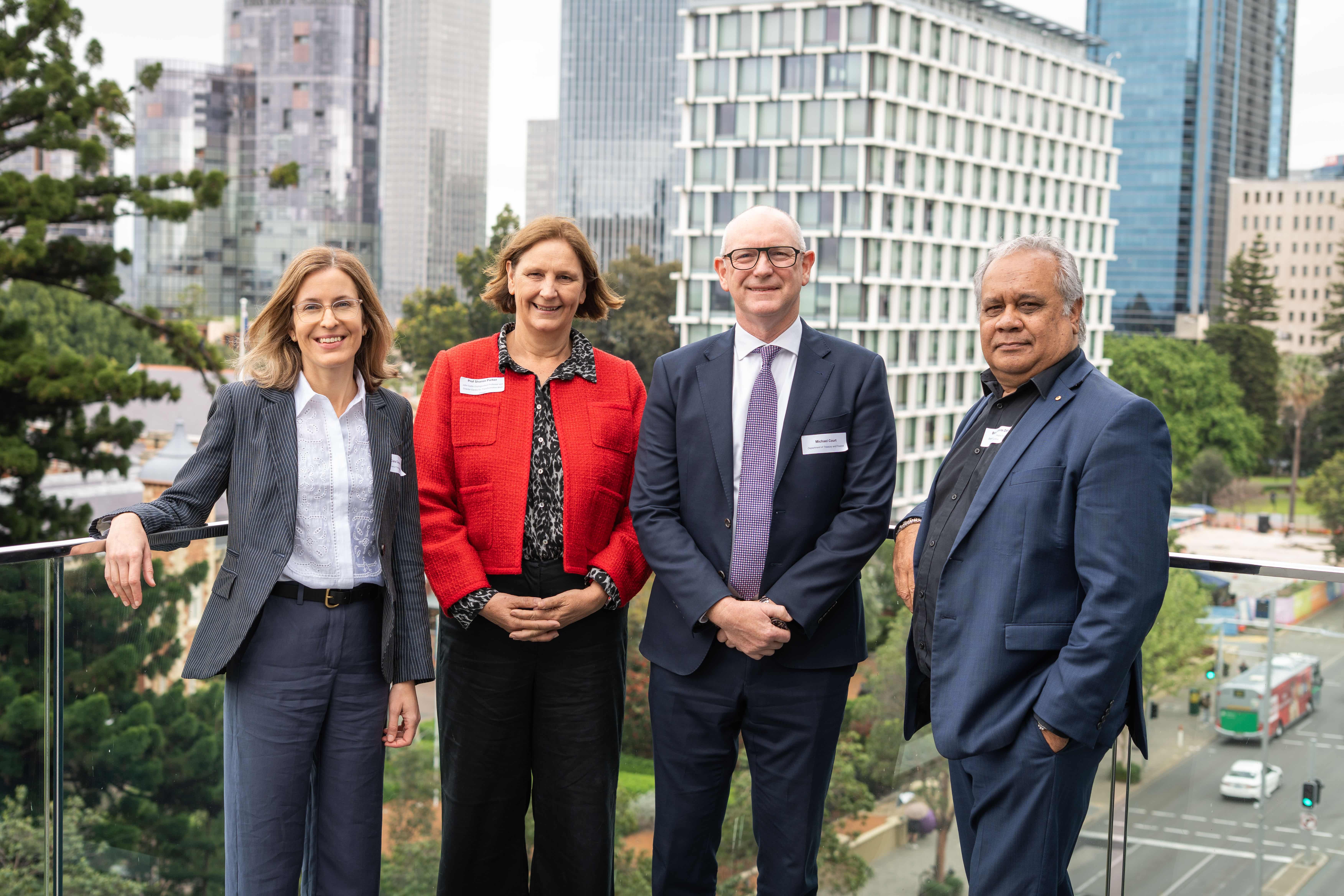 Photo of Clara Cuevas, Professor Sharon Parker, Michael Court and Barry McGuire OAM standing together on a balcony overlooking St Geroge's Terrace.