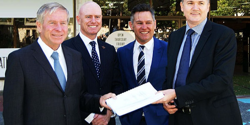 Colin Barnett and three men holding a document.