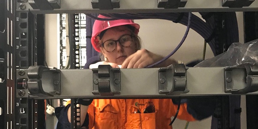 Female apprentice electrician working on Bob Hawke College building 2019
