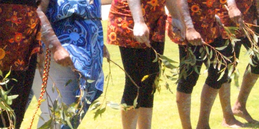 A close up view of people engaged in Aboriginal dancing.
