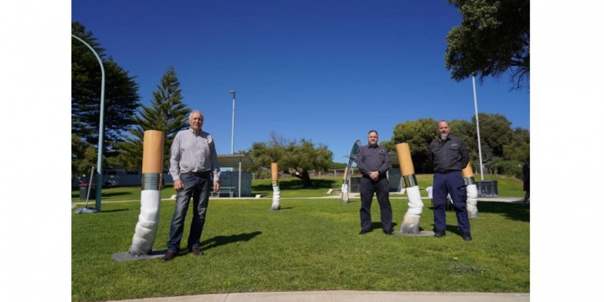 people standing near cigarette butts that are about as tall as a person