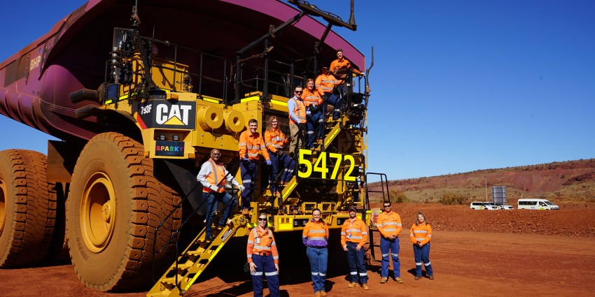 Mine workers in front of a large excavator