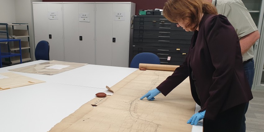 Two archivist examining map