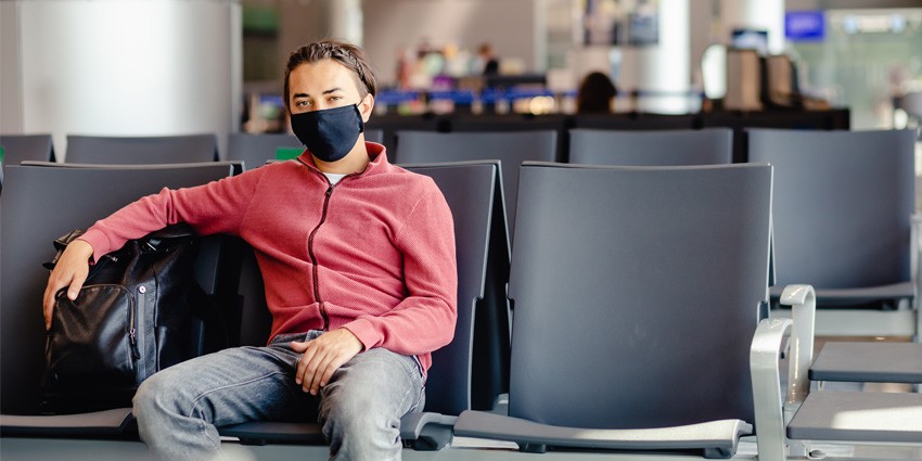 Man sitting at airport with mask on