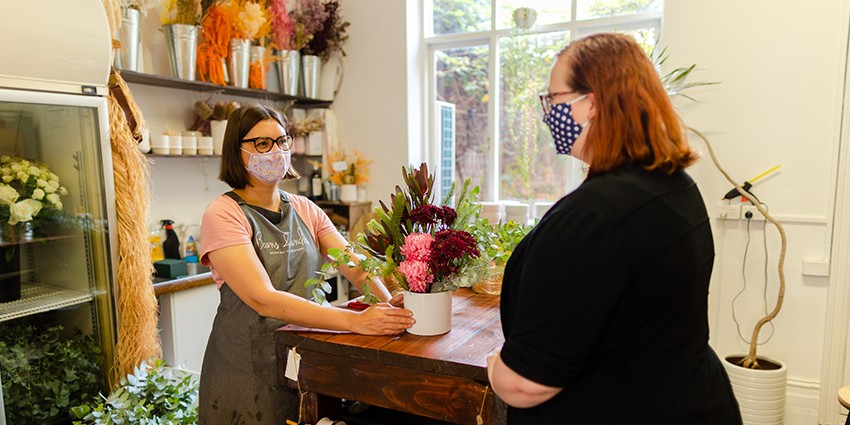 Florist and shopper wearing masks