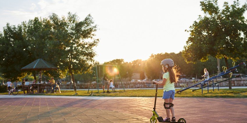 child riding scooter through park infrastructure