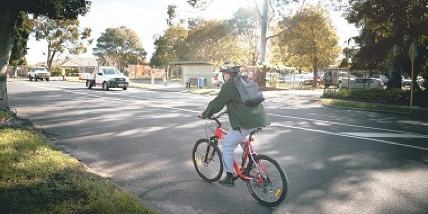 Man with backpack cycling on the road