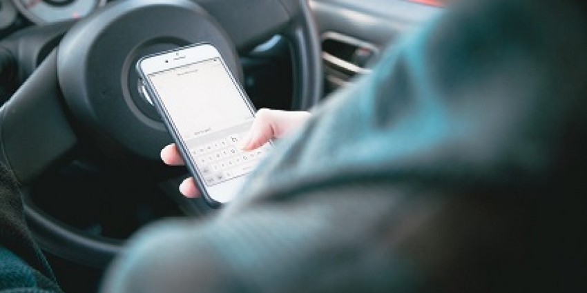 Using a phone to text message behind the wheel
