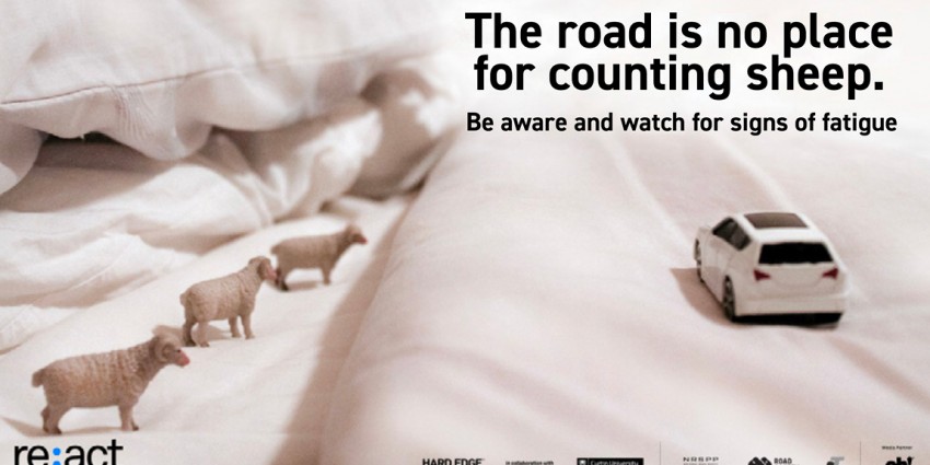 The road is no place for counting sheep banner. Car on bed with sheep