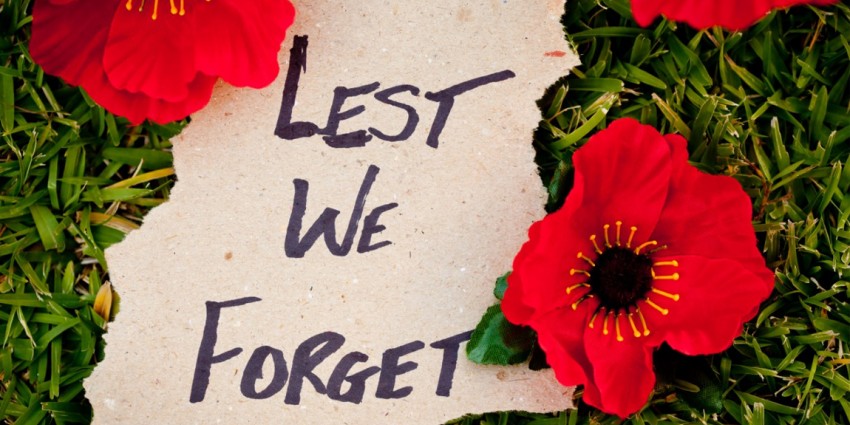 Note with Lest We Forget on grass with poppies