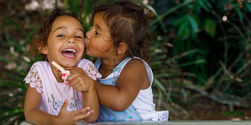 Two young Aboriginal children smiling and having fun.