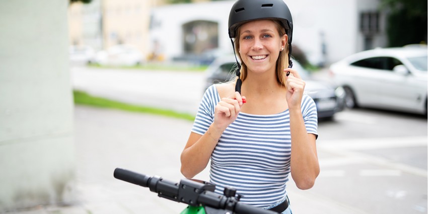 Woman putting on a helmet before riding an e-bike