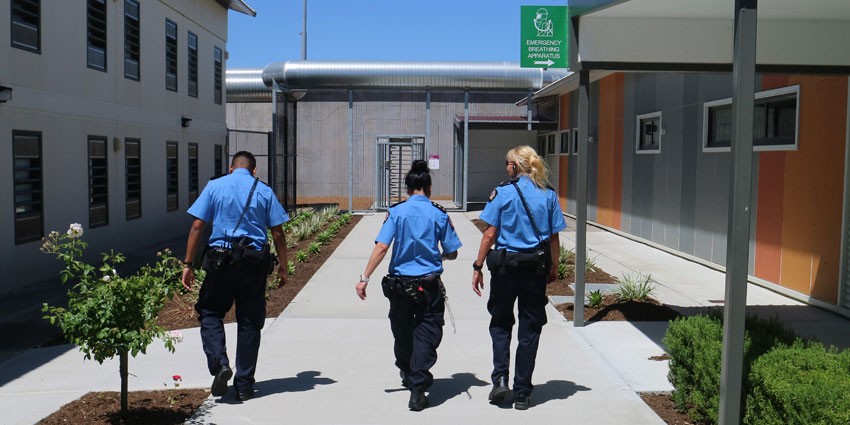 Officer trio from behind walking down path