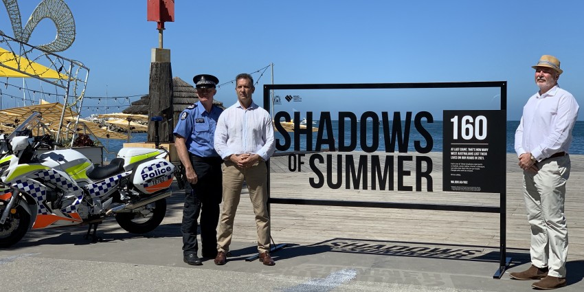Policeman and minister with shadows of summer campaign sign