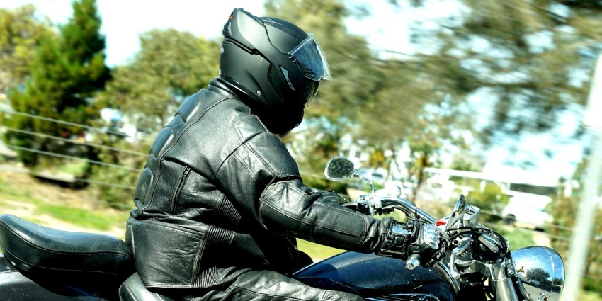 A motorcyclist wearing a jacket and a helmet