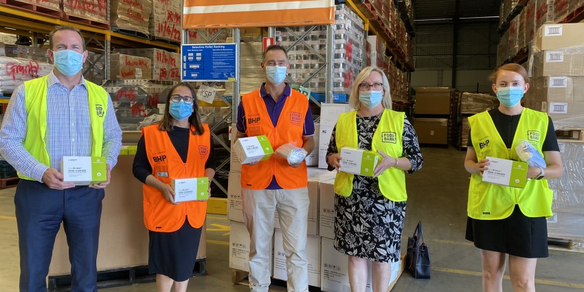 Troy Dennis, Fran Ferreira, Steve Martin, Catherine Stoddart and Lucy Granger at the Foodbank WA warehouse with some of the RAT kits and masks that will be distributed