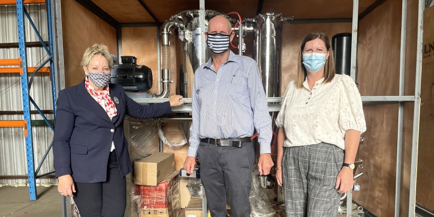 Regional Development Minister Alannah Mactiernan stands in a warehouse and is pictured in front of a high-tech piece of equipment used to process graphite. She stands with International Graphite Chairman Phil Hearse and Collie-Preston MLA Jodie Hanns
