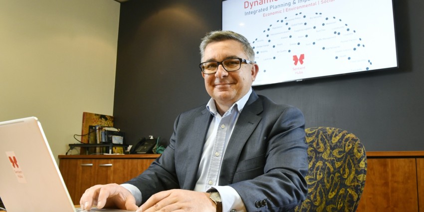 Image of David Lucido, managing director of Sentient Hubs, sitting at his desk with laptop open
