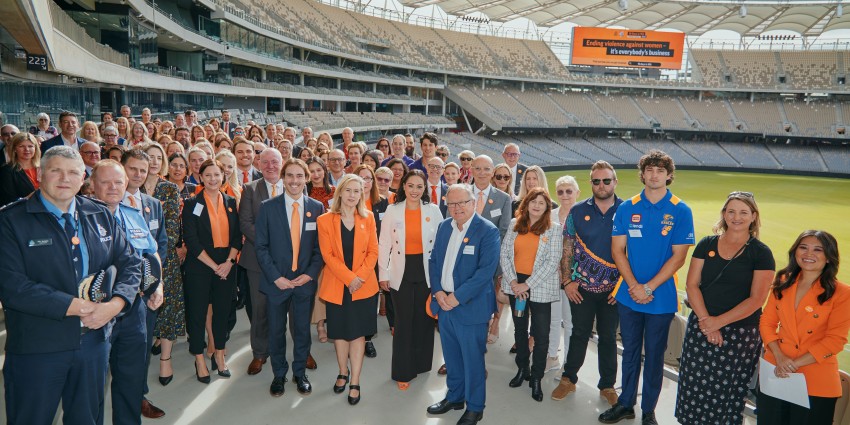 Photo of large group posing in grand stand at Optus Stadium