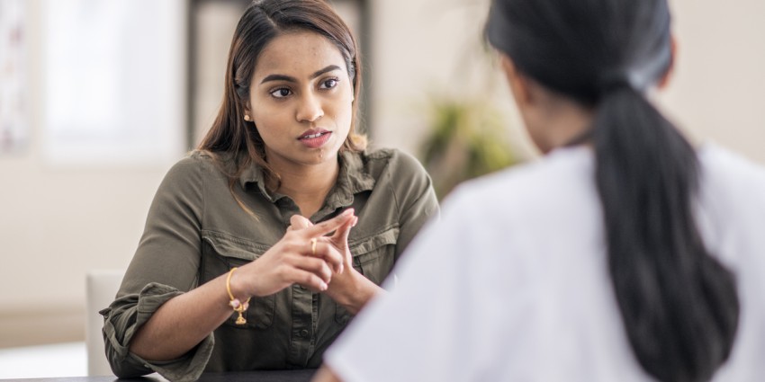 Two woman sitting in an office having a serious discussion about a complaint